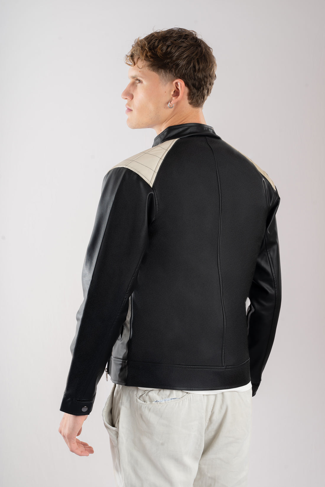 Chaqueta cuerotex negra con detalles beige de hombre vista espalda.