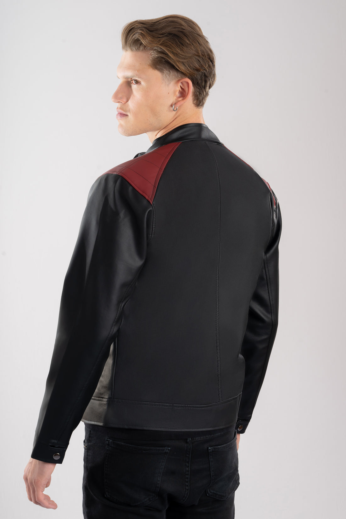 Chaqueta cuerotex negra con detalles rojos de hombre vista fespalda.