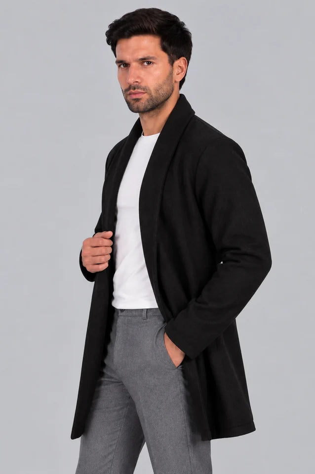 Hombre con un look sofisticado usando el Gabán Raba color negro en vista lateral, abrigo abierto de solapa ancha en paño cachemir.