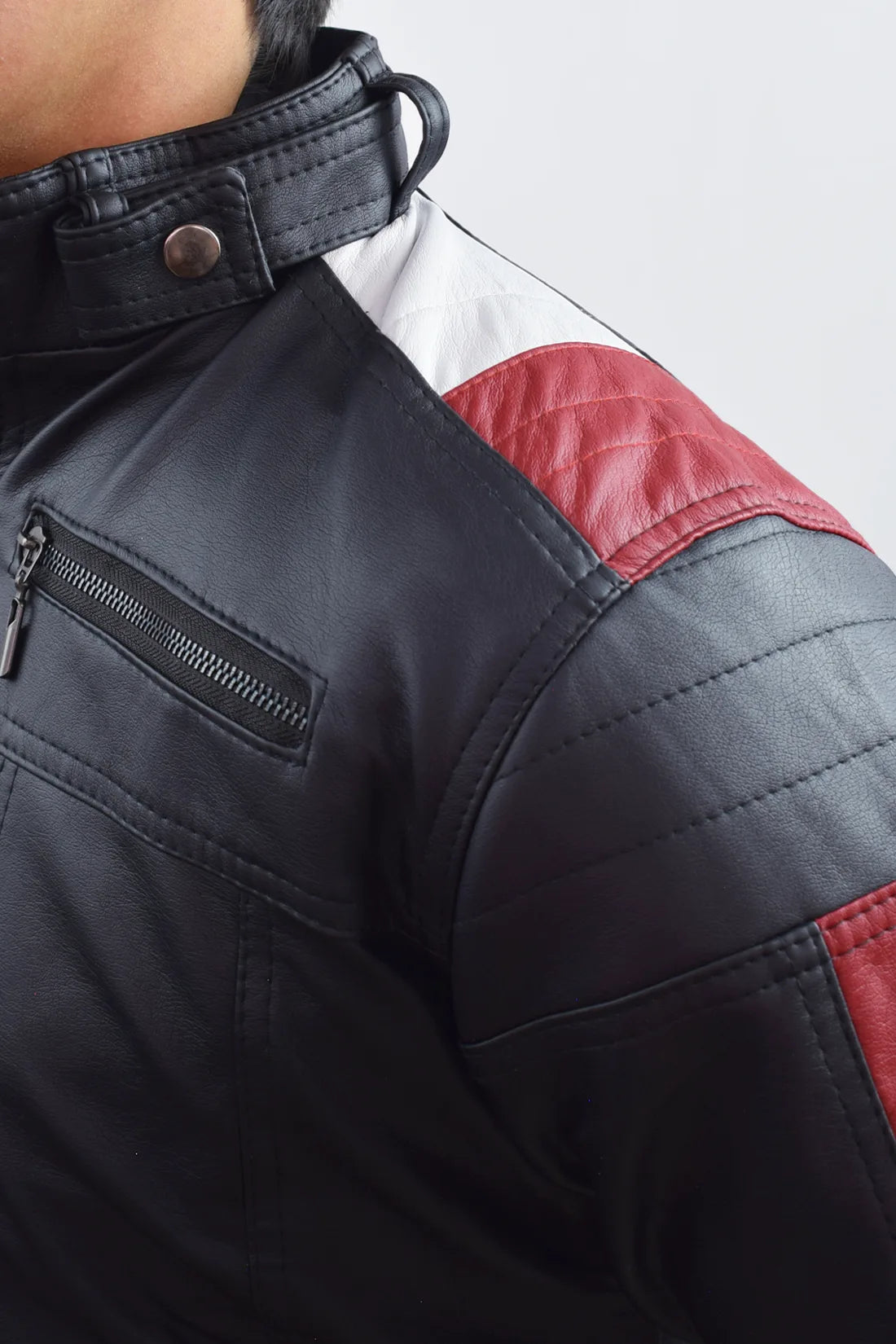 Primer plano del hombro y la textura del Cuerotex de la chaqueta minimalista AD22 negra con rayas rojas y blancas.