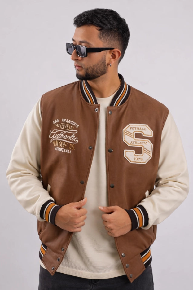 Chaqueta Bomber beisbolera para hombre vista frontal en color cafe claro con logos bordados y material Cuerotex resistente. Disponible con Pago Contra Entrega, crédito ADDI y Sistecrédito en lsjsas.com