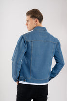 Vista trasera de la chaqueta de jean azul medio para hombre, mostrando el corte clásico y las correas de ajuste en la cintura.
