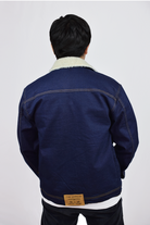 Vista trasera de la chaqueta de jean azul Industrial para hombre, mostrando el corte clásico y el tono deslavado del denim.