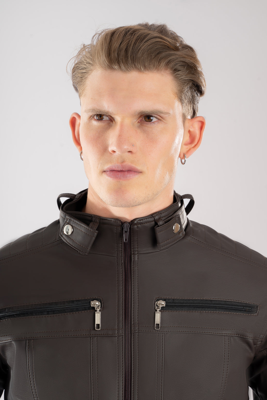 Primer plano del bolsillo con cremallera de la chaqueta de Cuerotex café, destacando su diseño limpio.