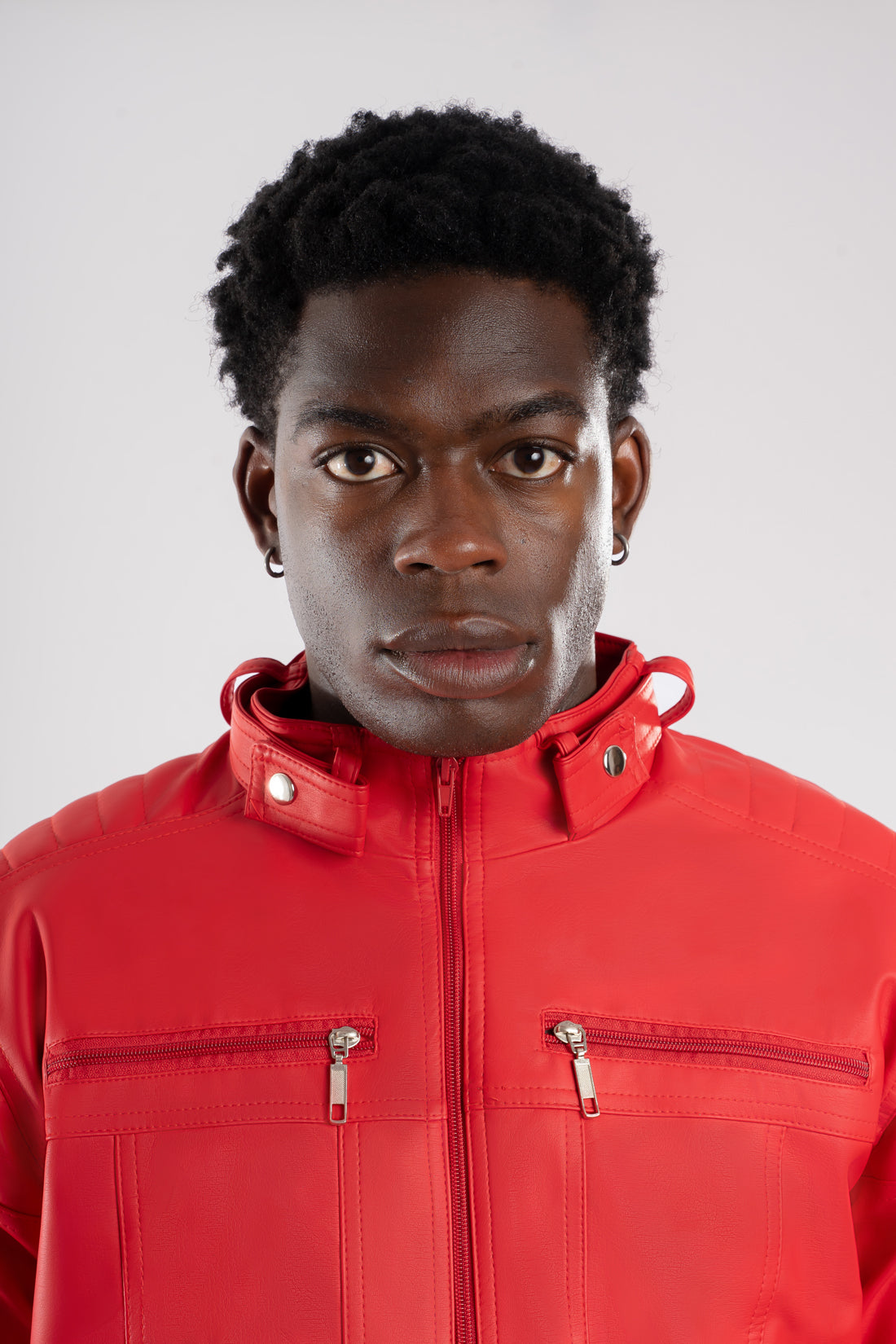 Primer plano del frente, cuello y la textura del Cuerotex roja de la chaqueta minimalista AD22.