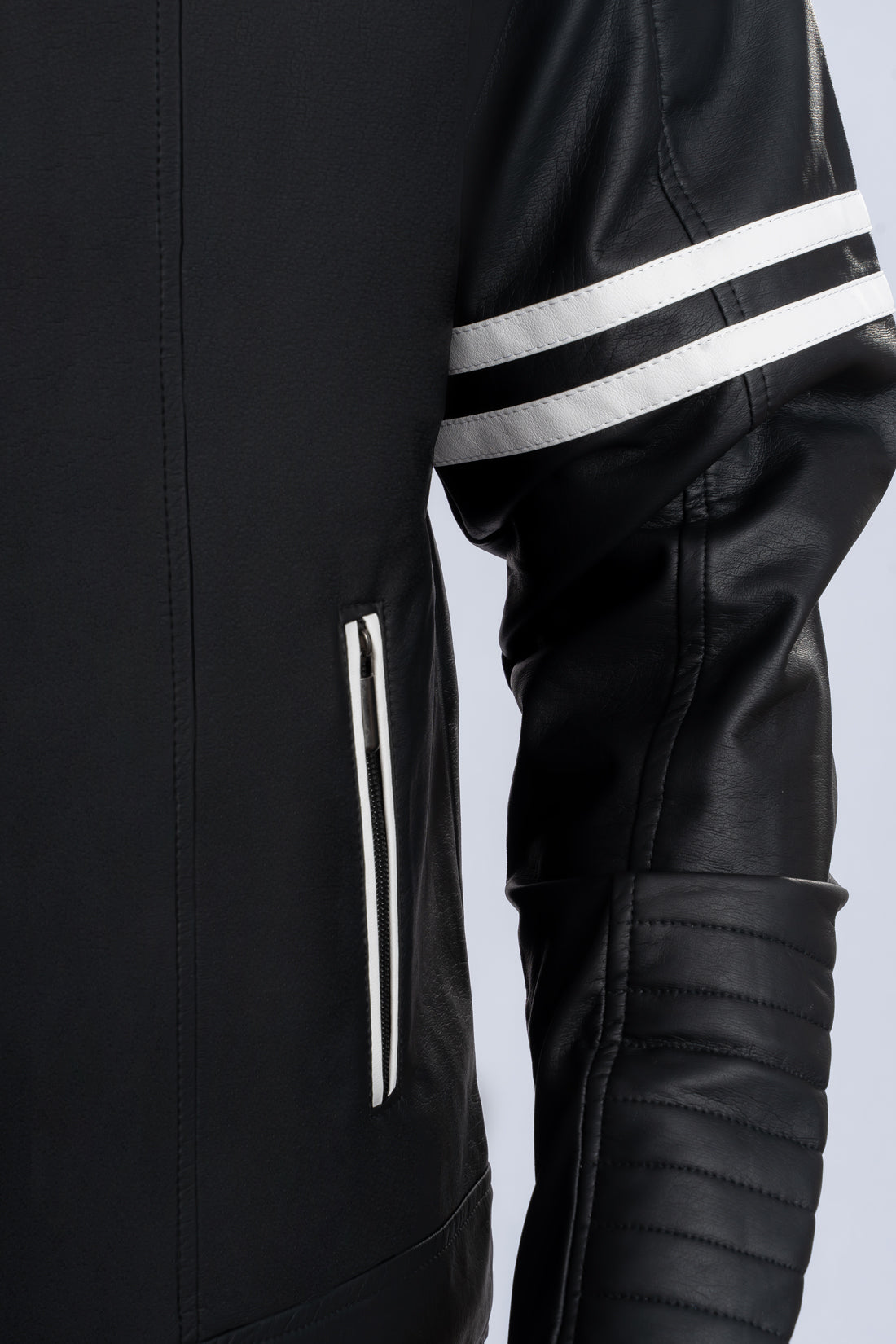 Primer plano de la textura y acabados de la chaqueta beisbolera negra blanca de LSJ SAS.