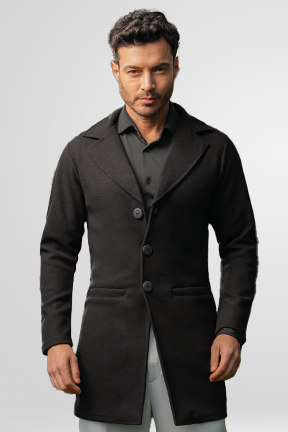 Primer plano de la textura del paño licrado y los botones de un gabán negro para hombre modelo Oriente.