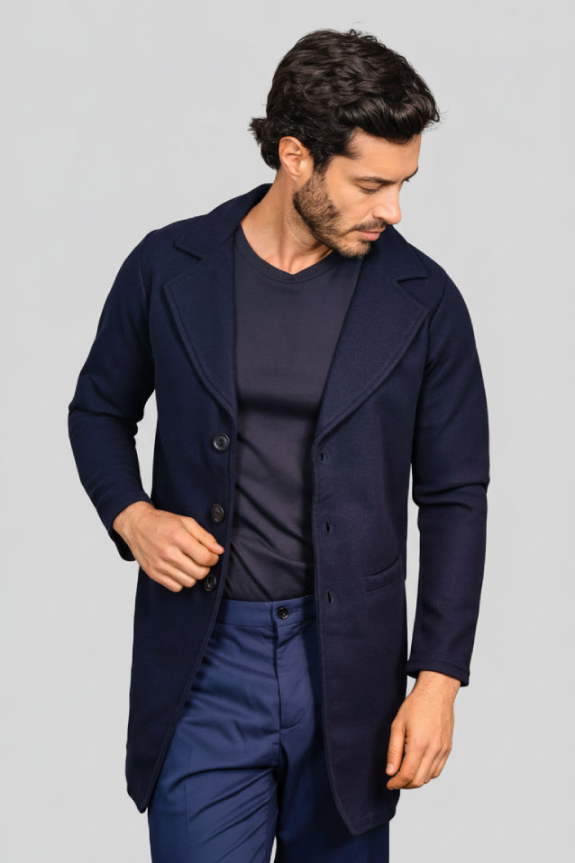 Hombre con estilo elegante vistiendo un gabán largo modelo Oriente en color azul oscuro (navy), vista frontal.