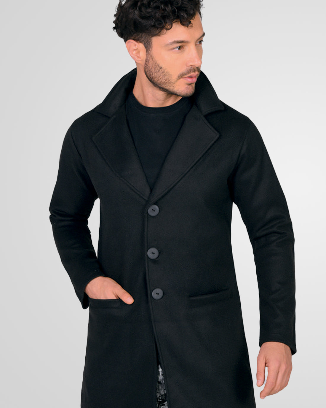 Hombre vistiendo un gabán moderno modelo Oriente en color negro, con corte largo y elegante, vista frontal.
