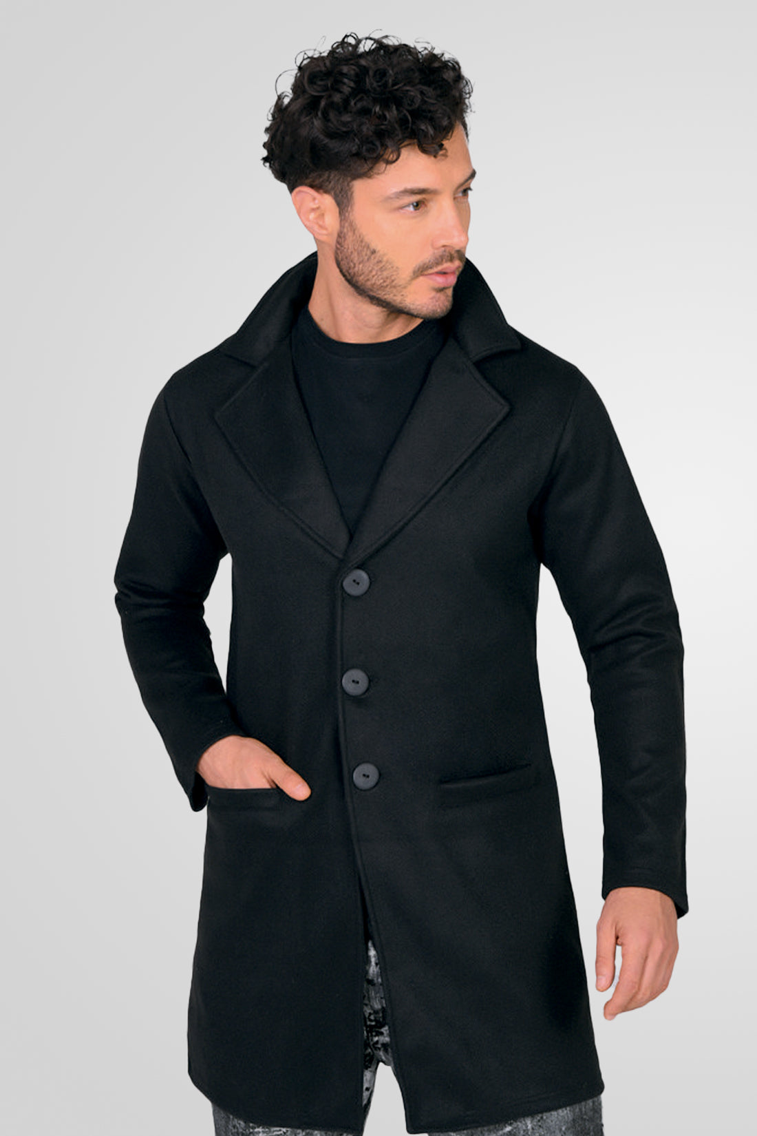 Hombre vistiendo un gabán moderno modelo Oriente en color negro, con corte largo y elegante, vista frontal.