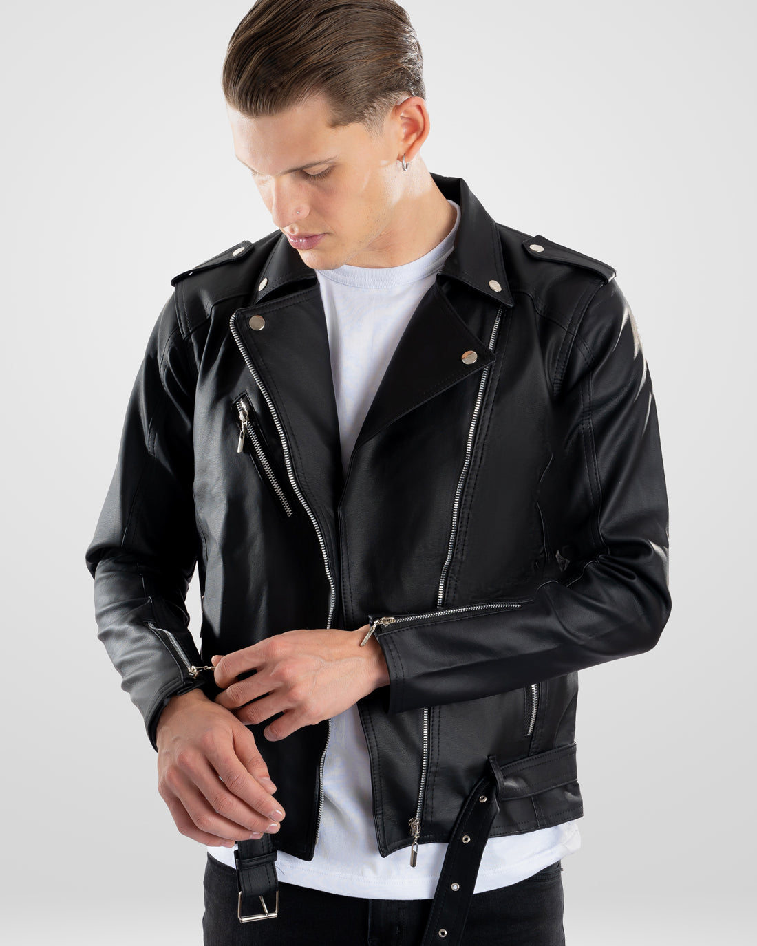 Hombre vistiendo una Chamarra de cuerotex negra para hombre, con un estilo rockero y detalle de correa y hebilla, vista frontal.