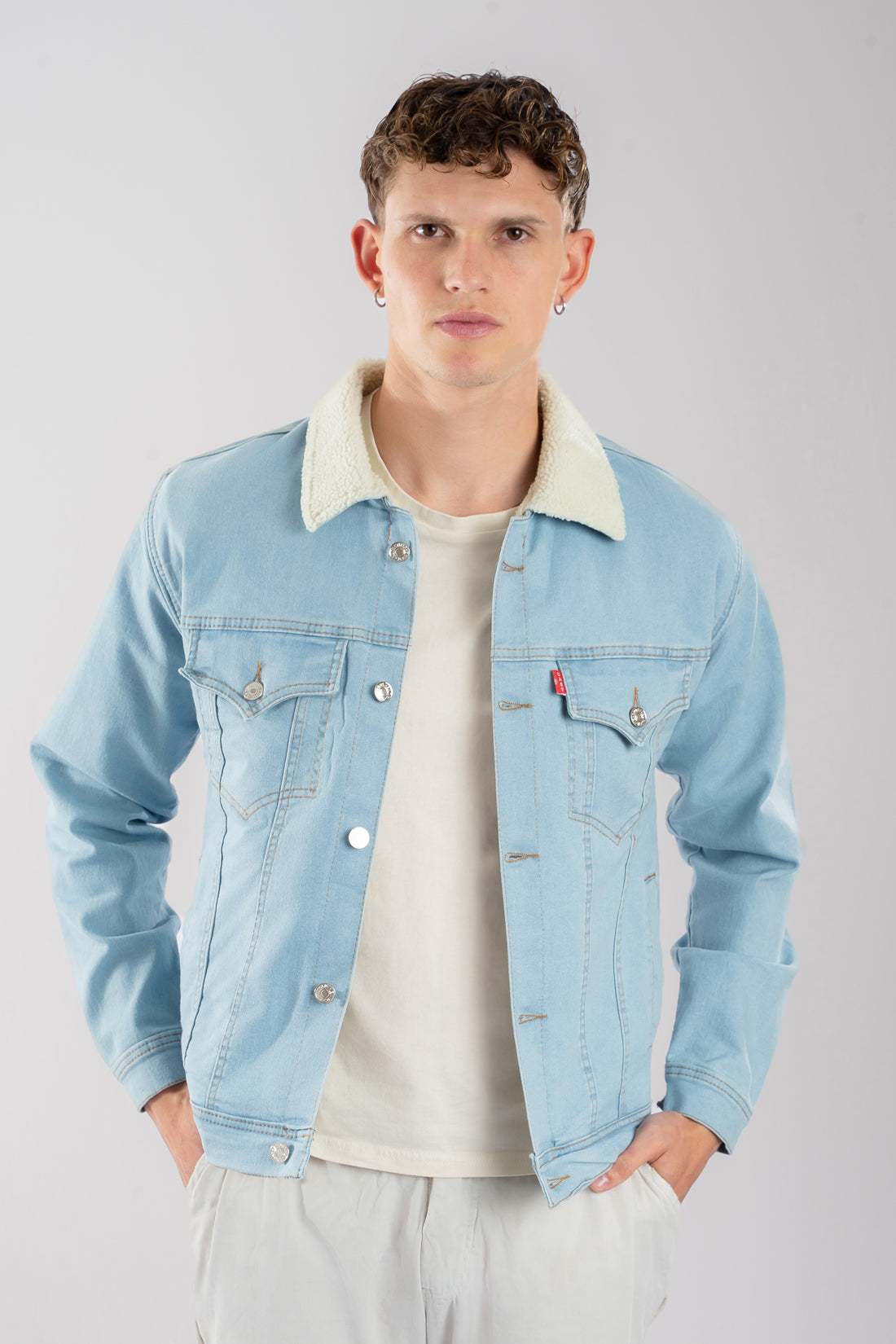 Hombre vistiendo una chaqueta de jean azul hielo con ovejero, mostrando un look vintage y relajado.