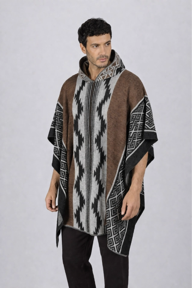 Hombre vistiendo una ruana cafe modelo Durango vista frontal, con capucha, patrones geométricos (grecas) y flecos artesanales.