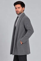 Hombre con un look sofisticado usando el Gabán Raba color gris en vista lateral, abrigo abierto de solapa ancha en paño cachemir.