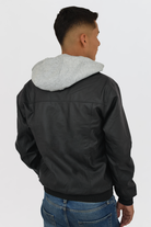 Hombre vistiendo la chaqueta de Cuerotex negra con capota de algodón, mostrando vista de espalda gracias a su corte resortado.