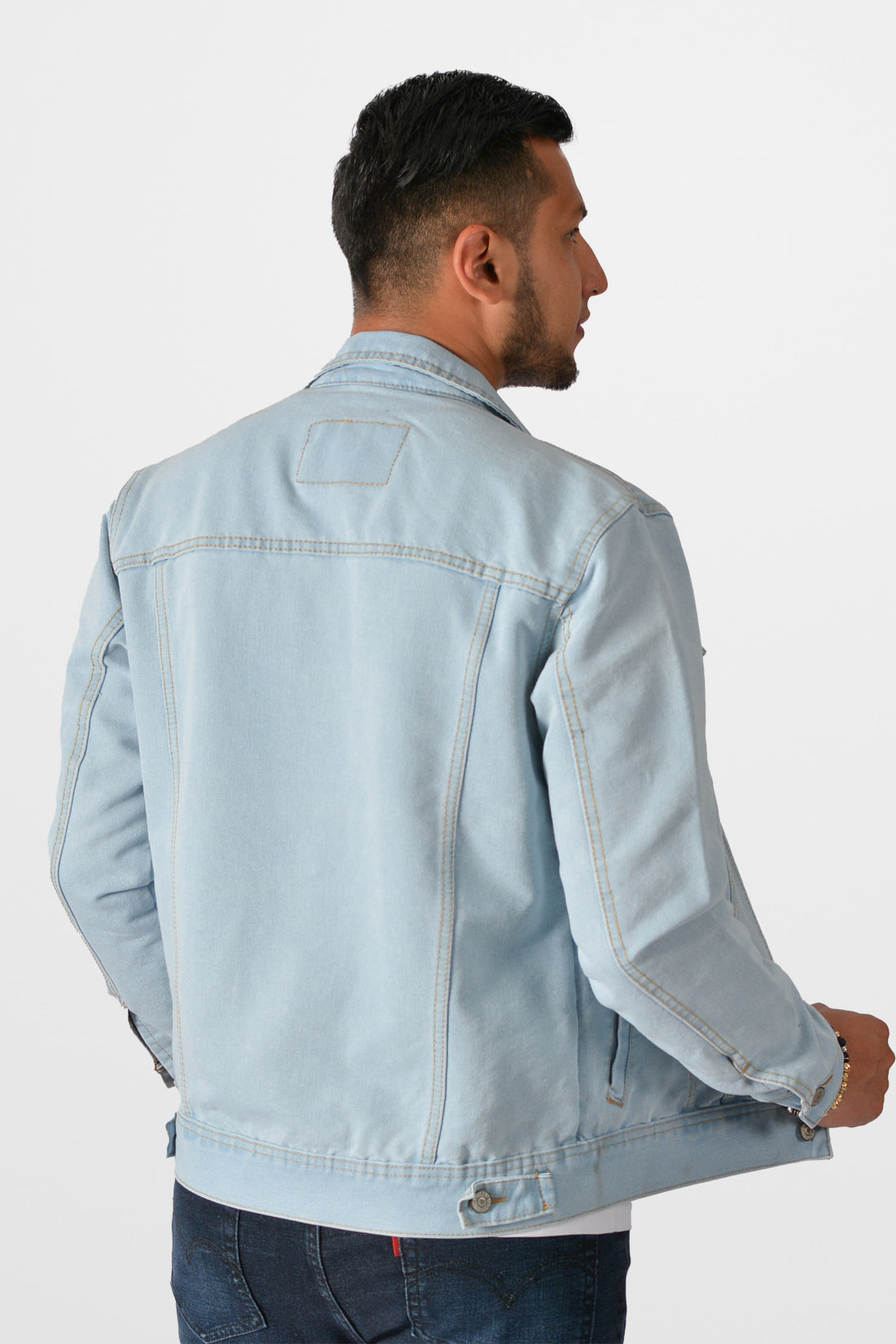 Vista trasera de la chaqueta de jean azul hielo para hombre, mostrando el corte clásico y las correas de ajuste en la cintura.