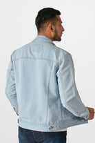 Vista trasera de la chaqueta de jean azul hielo para hombre, mostrando el corte clásico y las correas de ajuste en la cintura.