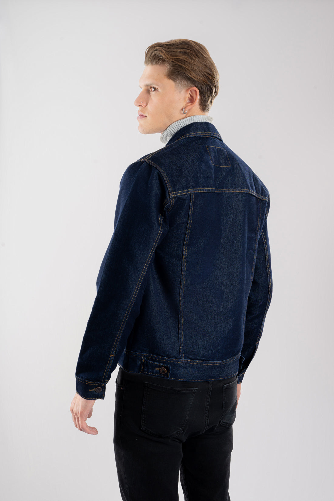 Vista trasera de la chaqueta de jean azul industrial para hombre, mostrando el corte clásico y las correas de ajuste en la cintura.