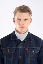 Vista frontal de la chaqueta de jean azul industrial para hombre, mostrando el corte clásico y cuello.