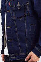 Chaqueta de jean azul industrial para hombre, con forro y cuello de ovejero blanco en contraste, vista lateral.