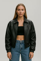 Chaqueta oversize negra para mujer en cuerotex, diseño urbano minimalista con cuello camisa y resortes.