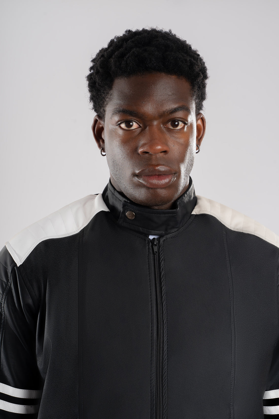 Vista detalles de chaqueta beisbolera negra blanca resaltando el corte y la calidad de confección nacional.