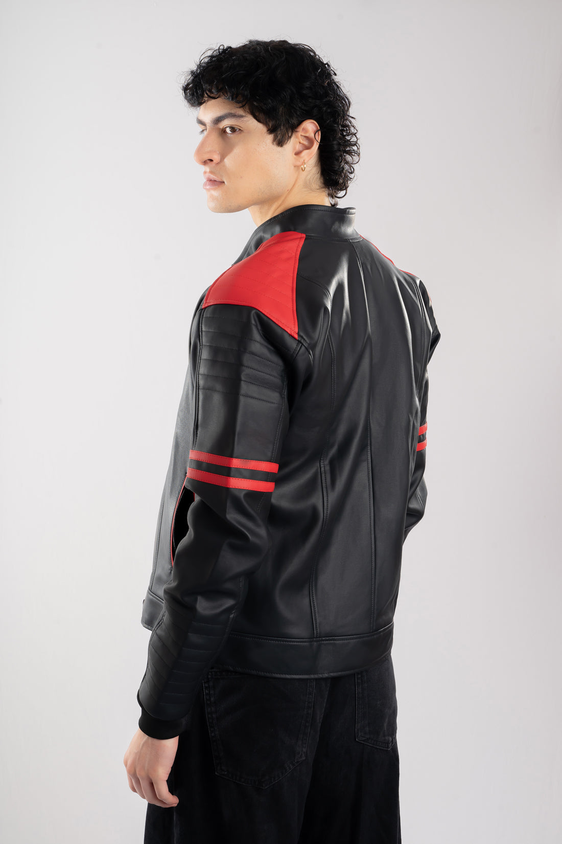 Vista posterior de chaqueta beisbolera negra roja resaltando el corte y la calidad de confección nacional.