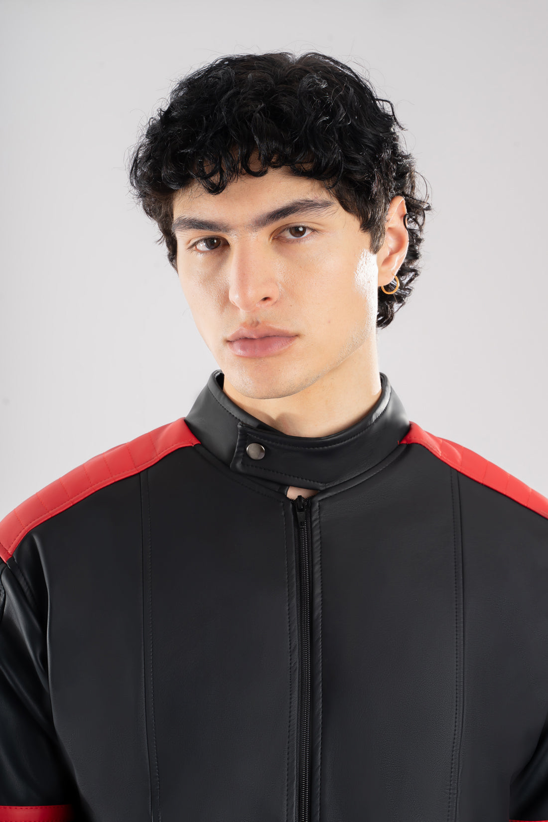 Vista detalles de chaqueta beisbolera negra roja resaltando el corte y la calidad de confección nacional.