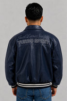  Vista espalda de la chaqueta Turbo azul para hombre en cuero sintético, estilo bomber con puños y cuello en rib.