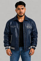 Vista frontal de la chaqueta Turbo azul para hombre en cuero sintético, estilo bomber con puños y cuello en rib.
