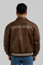 Espalda de la chaqueta beisbolera oversize café con bordado en relieve y resorte rayado en el ruedo
