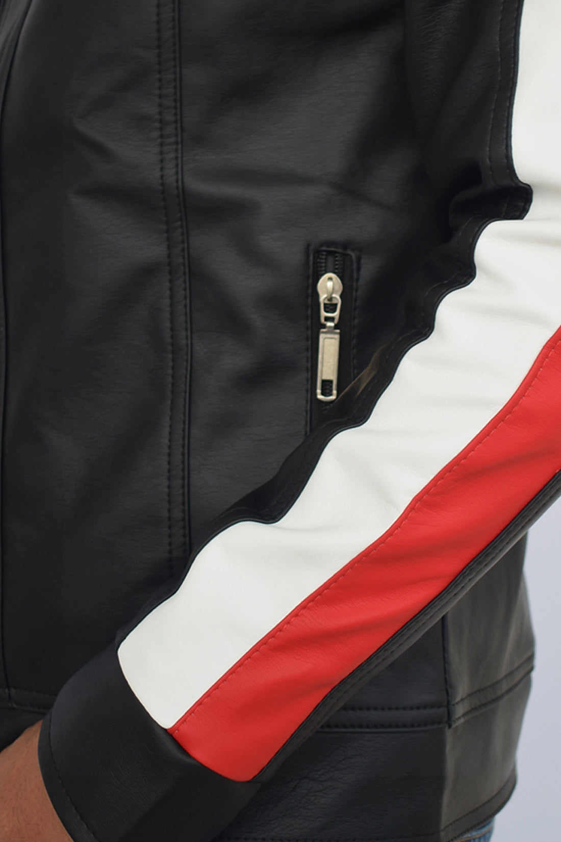 Primer plano del brazo, frente y la textura del Cuerotex negro con rayas rojas y blancas de la chaqueta minimalista AD22.