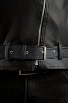 Primer plano cintura de la Chamarra de cuerotex para hombre en color negro, estilo rebelde con hebilla, vista frontal.