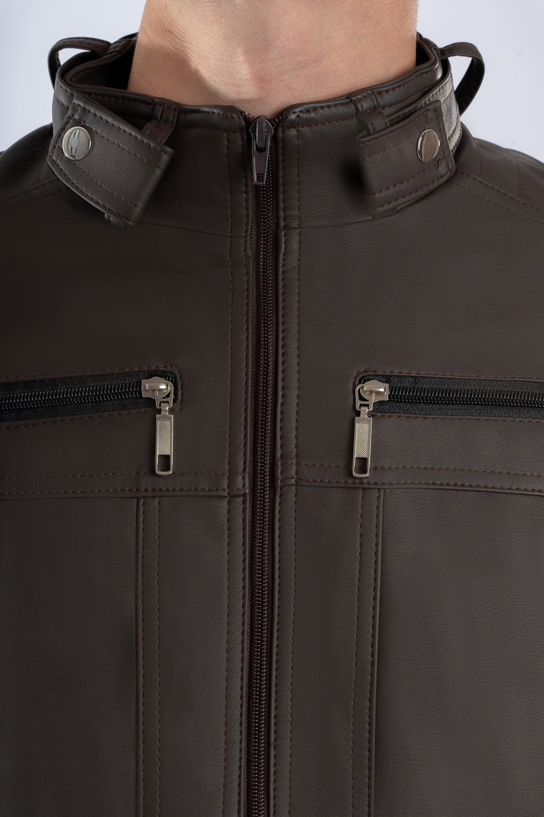 Primer plano de la cremallera y la textura del Cuerotex cafe oscuro de la chaqueta minimalista AD22.