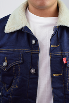 Primer plano de la textura del frente y el cuello de una chaqueta de jean ovejero azul industrial de hombre.