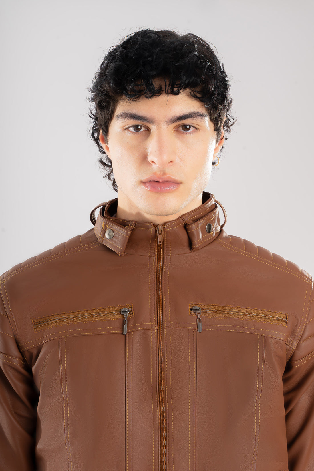 Primer plano del frente, cuello y la textura del Cuerotex cafe claro de la chaqueta minimalista AD22.