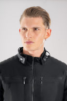 Primer plano del frente, cuello y la textura del Cuerotex negro de la chaqueta minimalista AD22.