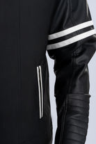 Primer plano de la textura y acabados de la chaqueta beisbolera negra blanca de LSJ SAS.