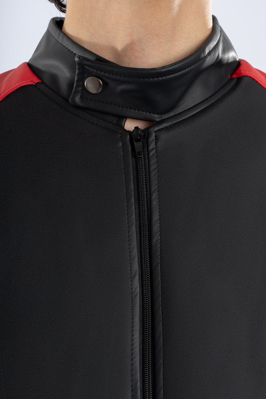 Primer plano de la textura y acabados de la chaqueta beisbolera negra roja de LSJ SAS.