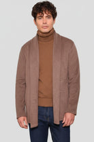 Hombre vistiendo el Gabán Raba color caramelo, una prenda de lujo relajado en paño cachemir con solapa ancha.