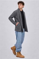 Hombre con un look informal usando el Gabán Raba gris, abrigo abierto de solapa ancha en paño cachemir.