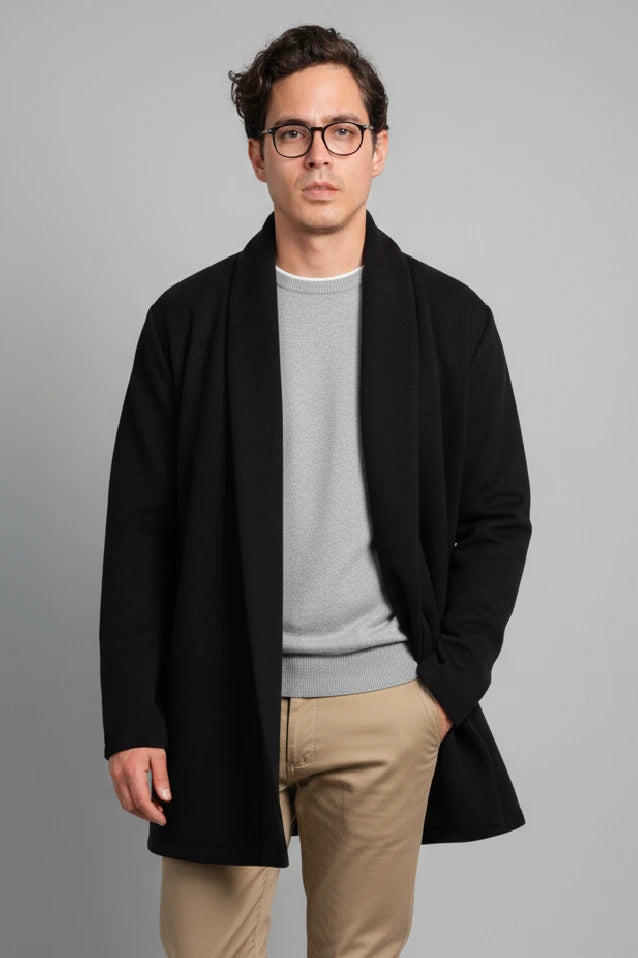 Hombre vistiendo el Gabán Raba en color negro, destacando su diseño abierto con solapa ancha y confección en paño cachemir.