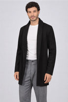 Hombre vistiendo el Gabán Raba en color negro en vista frontal, destacando su diseño abierto con solapa ancha y confección en paño cachemir.