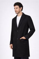 Hombre vistiendo el Gabán Saga color negro de LSJ SAS, confeccionado en paño licrado premium con corte elegante de 96 cm de largo.