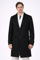 Hombre vistiendo el Gabán Saga negro de LSJ SAS en vista frontal, confeccionado en paño licrado premium con corte elegante de 96 cm de largo.