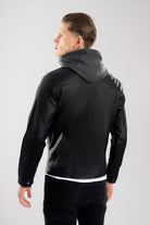 Hombre vistiendo la chaqueta de Cuerotex negra con capota de algodón, mostrando un look en su espalda elegante y moderno gracias a su corte recto.