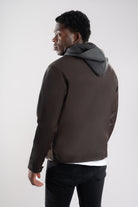 Hombre con un look casual y elegante vista de espalda de la chaqueta 2-en-1 de Cuerotex café oscuro con corte recto.