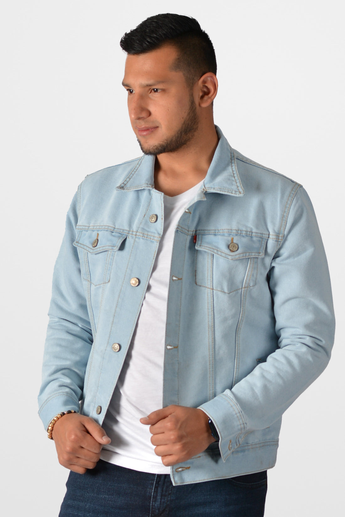 Hombre sonriendo vistiendo una chaqueta de jean azul hielo (clara), mostrando un estilo relajado y retro.