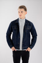 Hombre vistiendo una chaqueta de jean azul industrial, mostrando un look casual y atemporal para el día a día.