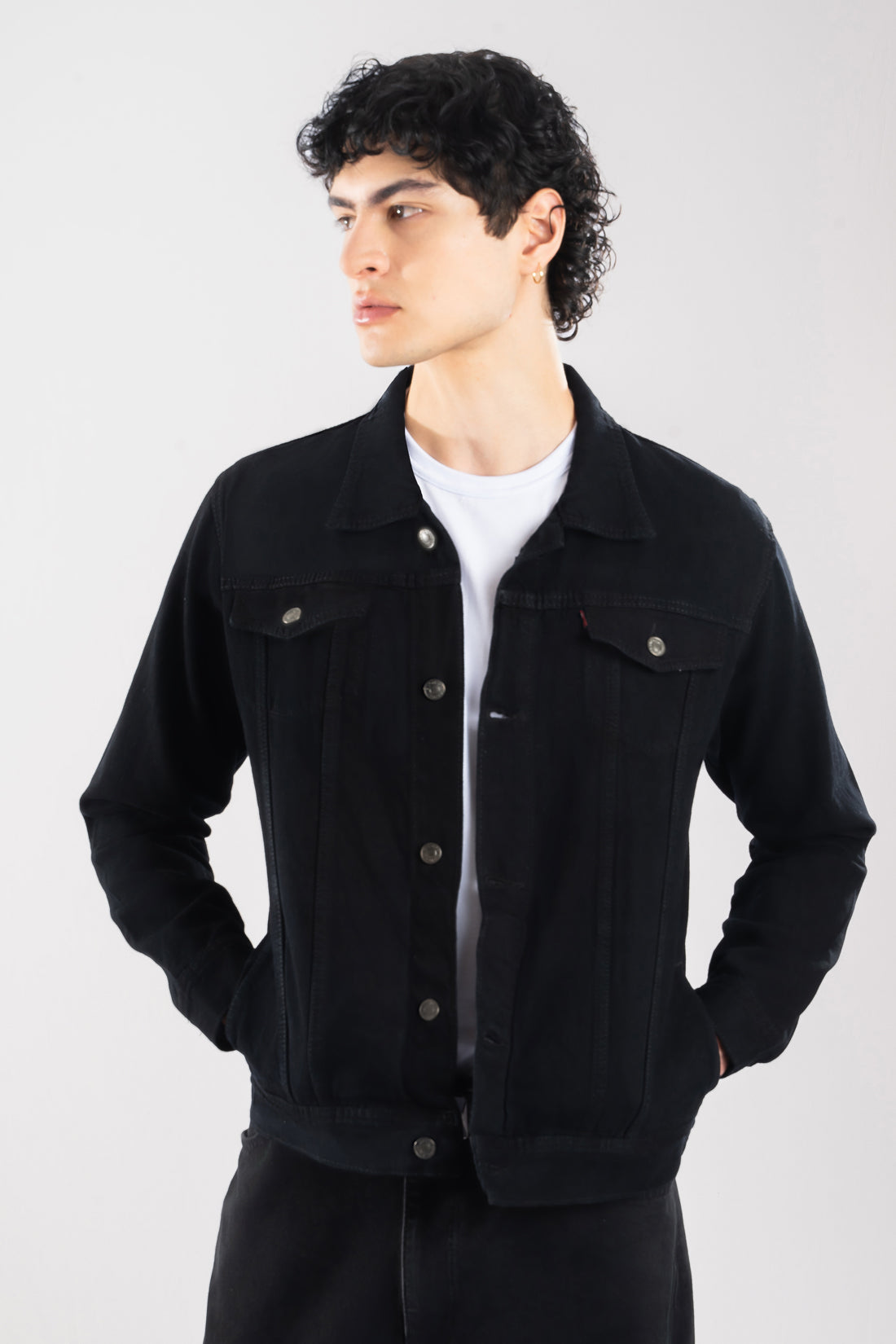 Hombre con un look urbano moderno vistiendo la chaqueta de jean negra clásica de LSJ.